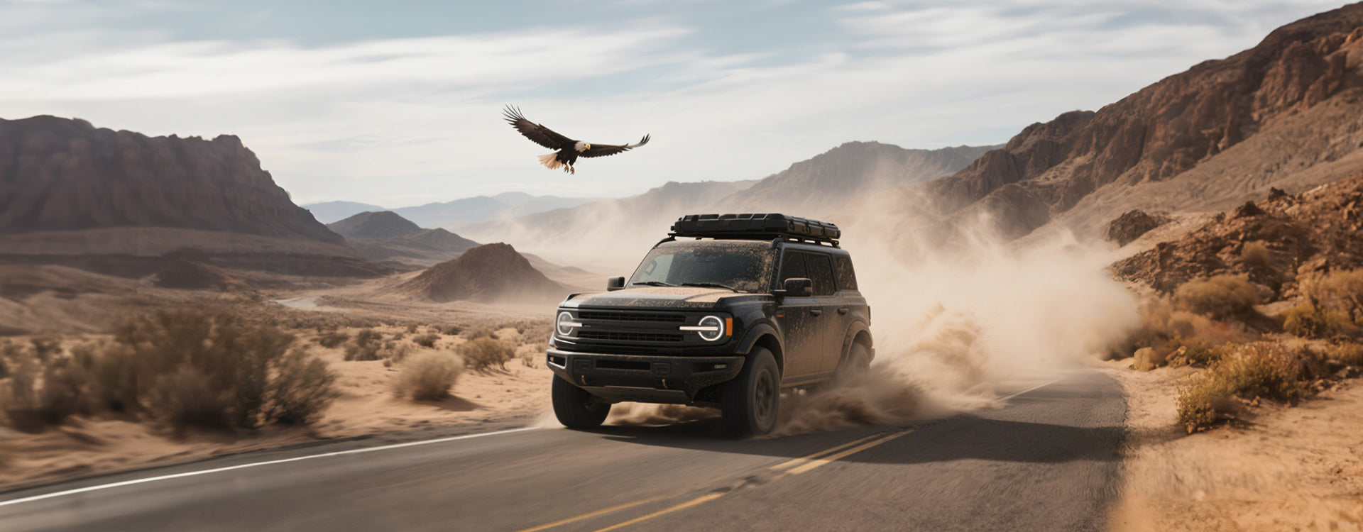 SUV driving on a desert road with an eagle flying overhead