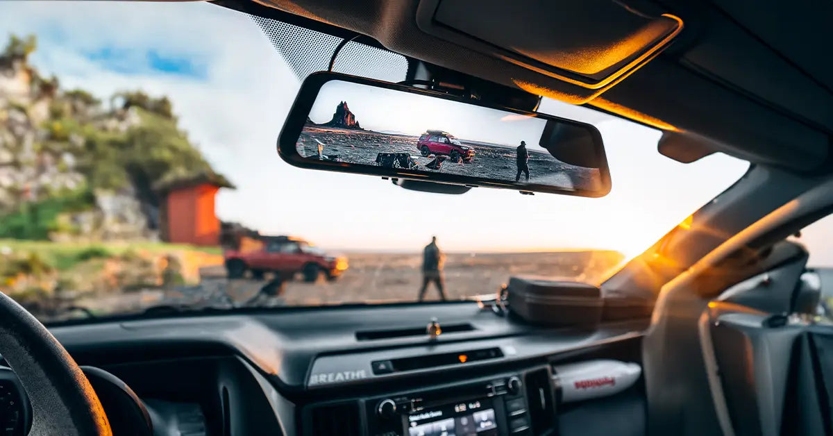 Car interior with a view of a scenic landscape through the windshield.
