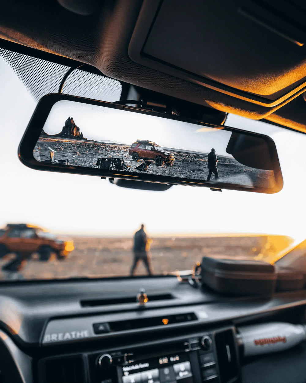 Mirror dash cam mounted inside a vehicle displaying a rear landscape view through the touchscreen display