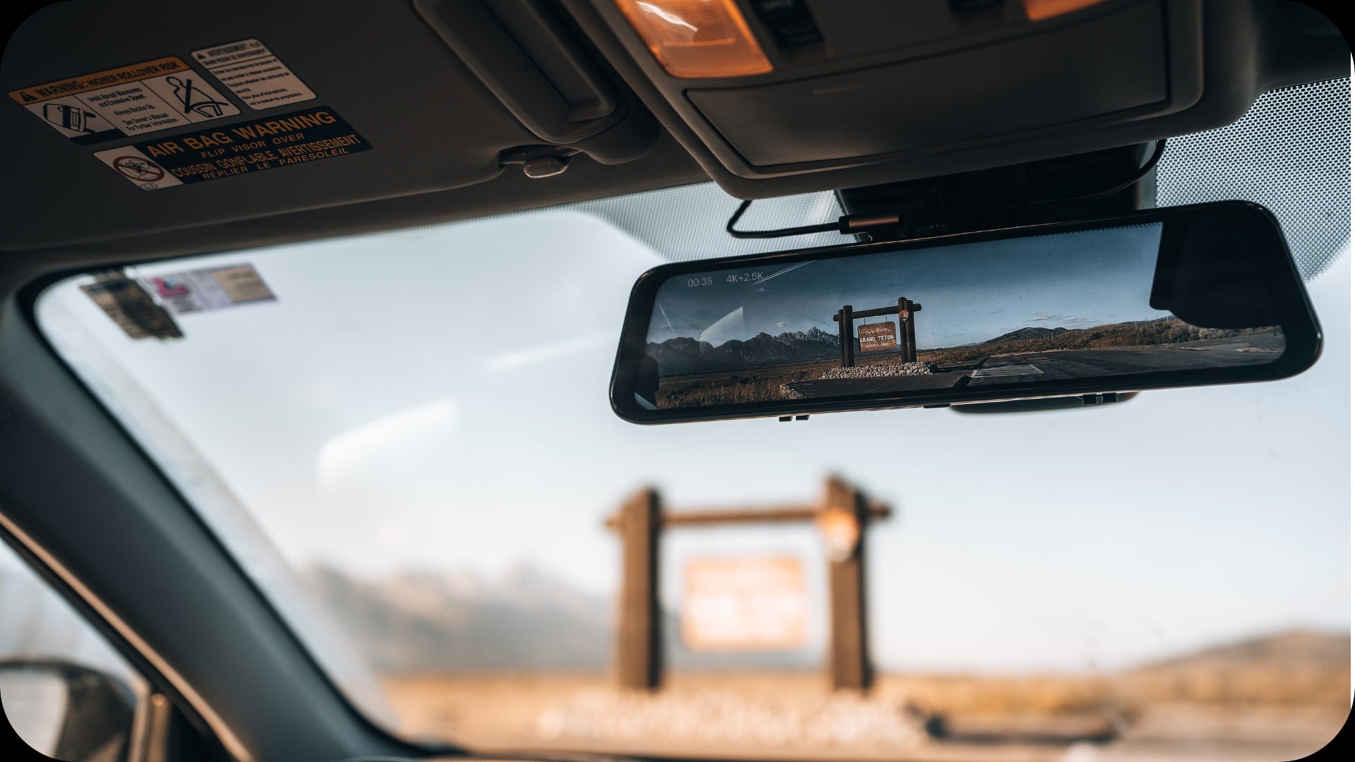 Smart rearview mirror dash cam displaying road view inside a car